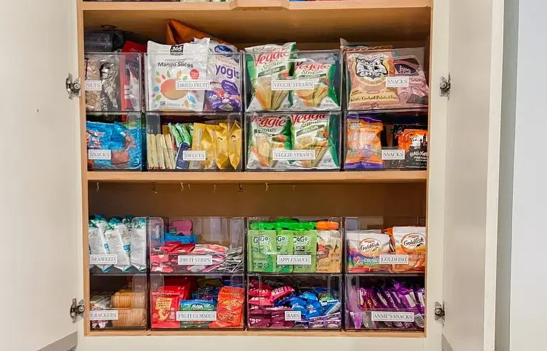 An organized pantry with acrylic storage bins